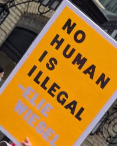 Protest sign displaying: No human is Illegal —Elie Wiesel