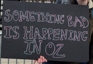 Protest sign displaying: Something bad is happening in oz.