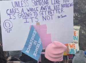 Protest sign displaying: Unless someone like you cares a whole awful lot, nothing is going to get better. It's not. —Dr. Suess