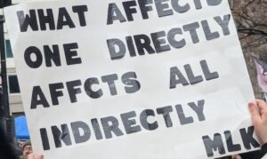 Protest sign displaying: what affects one directly affects all indirectly. —MLK
